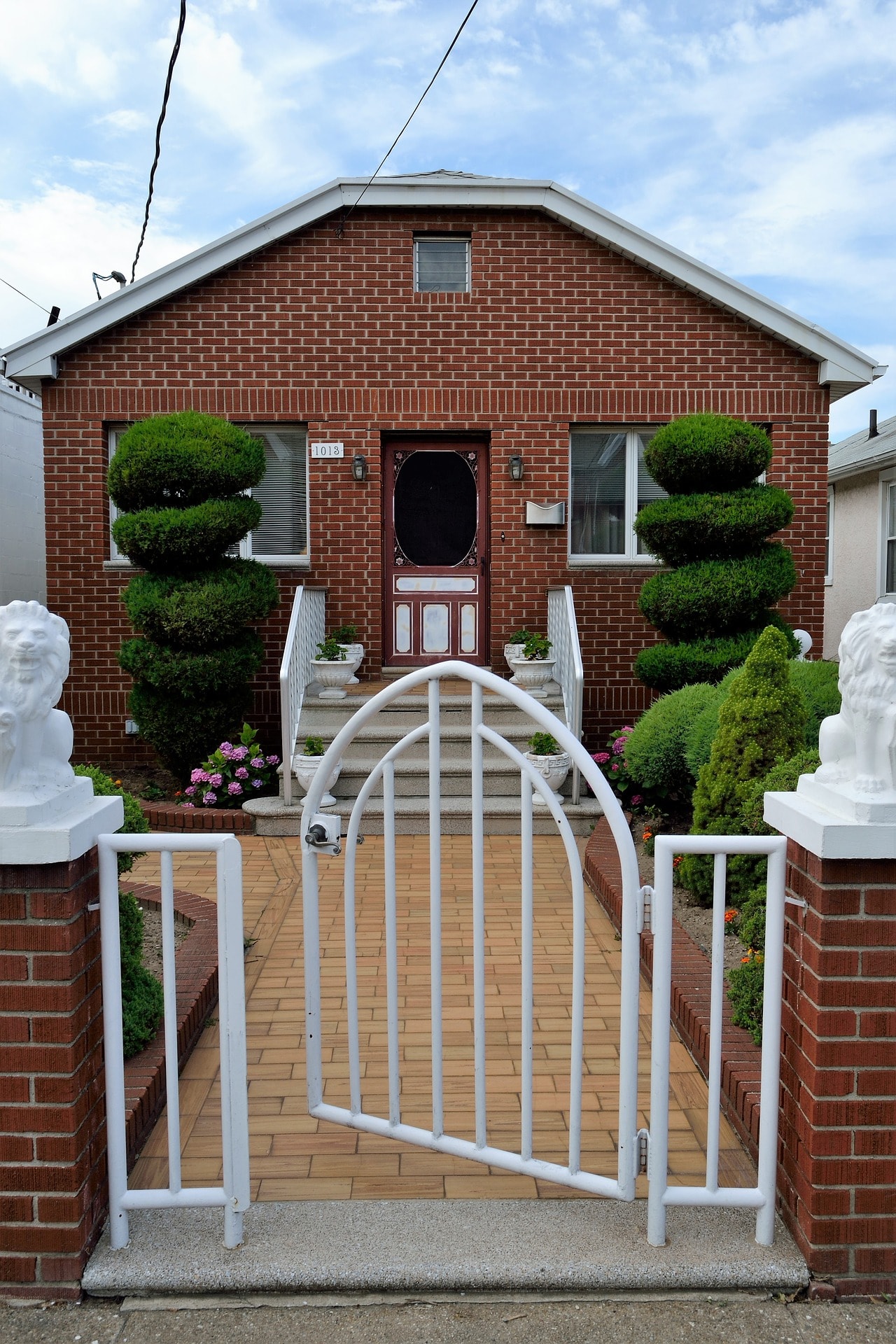 A one story brick structured house with white gate